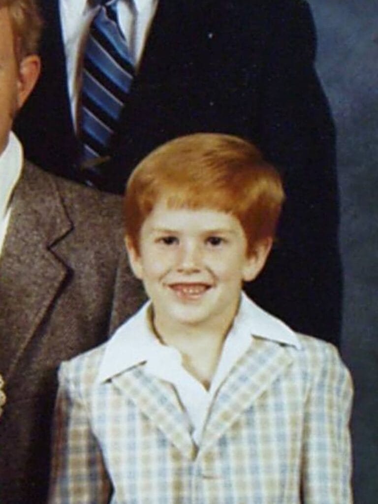 Young Paul Ferney smiling in a plaid jacket, a vintage childhood portrait